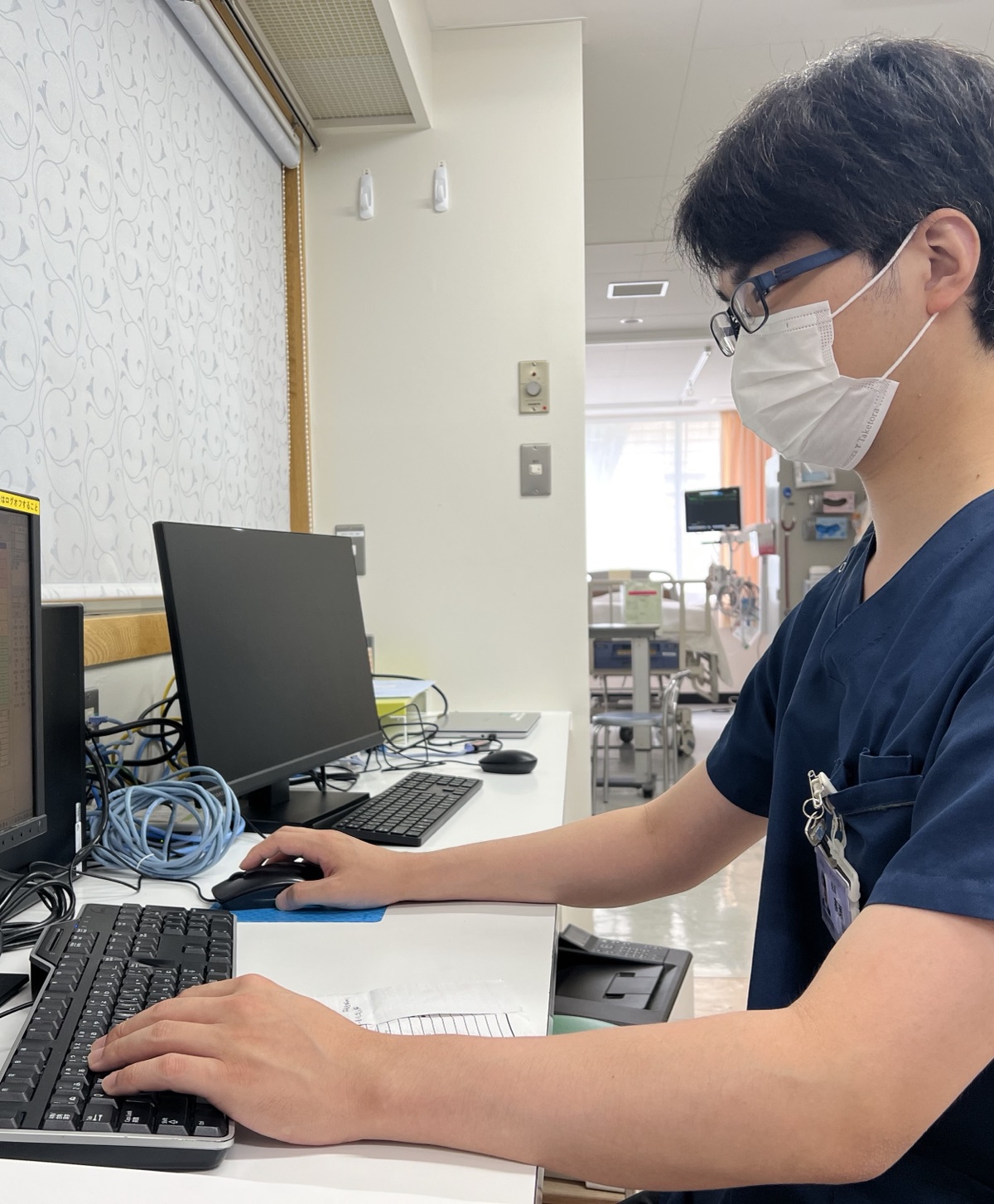 病棟の端末で診療情報を確認する研修医